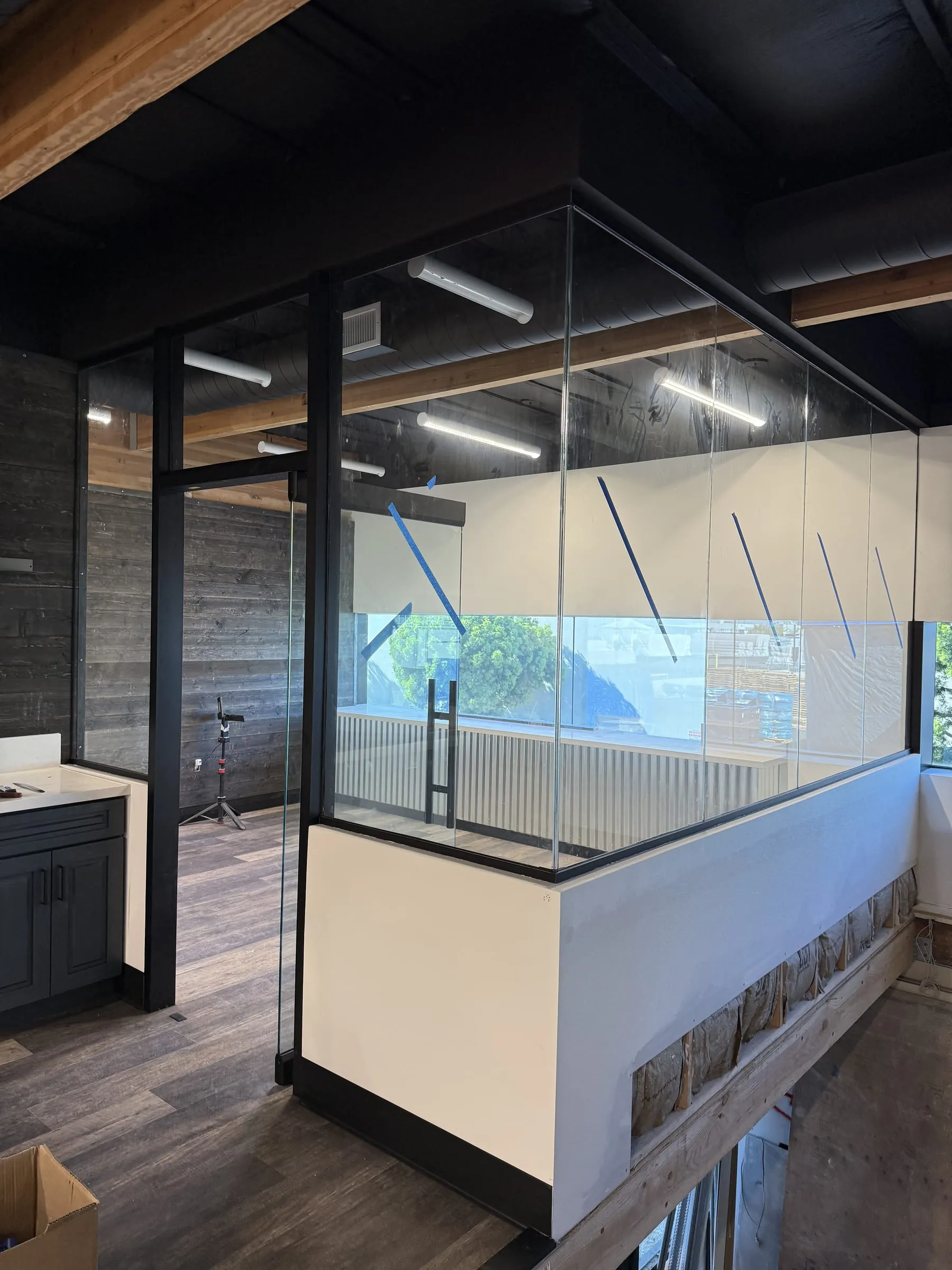 Glass office enclosure seen from the open office floor