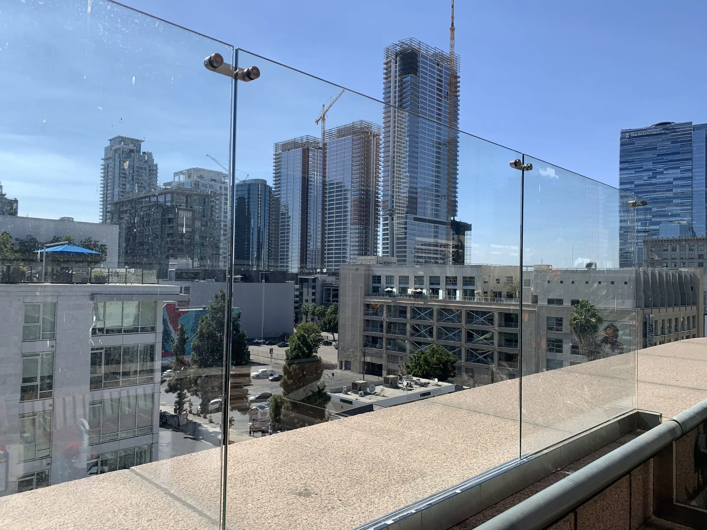 Rooftop frameless glass railing with a view of downtown towers